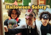 Three children in costumes trick or treating.